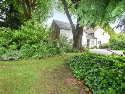 a house with a tree in front of a yard at Home Farm Barn in Pontesbury
