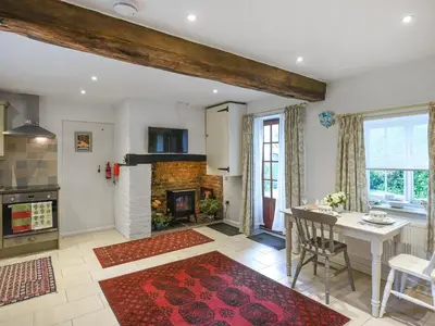 a kitchen and living room with a table and a fireplace at Home Farm Barn in Pontesbury
