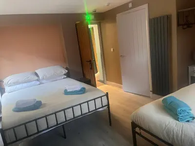 a room with two beds and a green light at Tumbledown Hotel in Shrewsbury