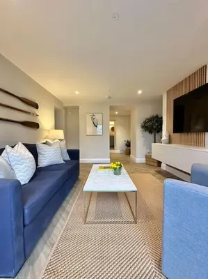 a living room with a blue couch and a table at Tobias Apartment, 2 Bedroom, Aberaeron in Aberaeron