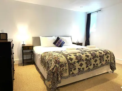 a bedroom with a bed with a blanket and a window at The Bear Apartments in Llandovery