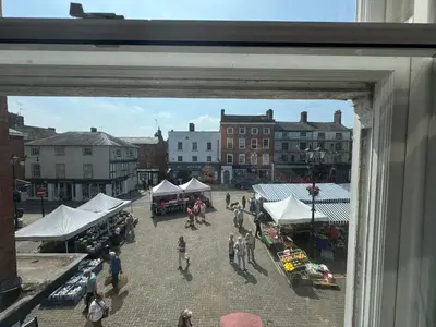 a group of people walking around a market with tents at The Nook Castle Street Ludlow in Ludlow