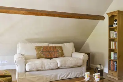 a white couch in a living room with a book shelf at The Old Chapel Charming countryside retreat - Pass the Keys in Ludlow