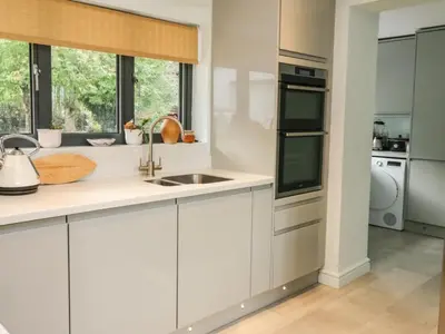 a kitchen with white cabinets and a sink at Trevonnen in Llyswen