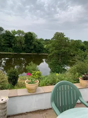 a green chair sitting on a balcony overlooking a pond at Trevonnen in Llyswen