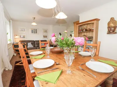a dining room with a wooden table and chairs at Plum Hill in Oswestry