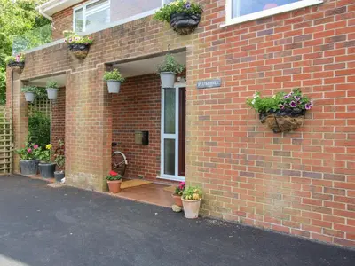 a brick house with potted plants on the side of it at Plum Hill in Oswestry