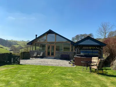 a house with a gazebo in a yard at Red Kite Cottage in Llangunllo