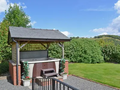 a gazebo with a grill in a yard at Red Kite Cottage in Llangunllo