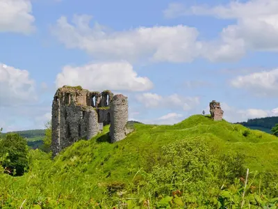 a castle on top of a green hill at Heyope Cottage in Llangunllo