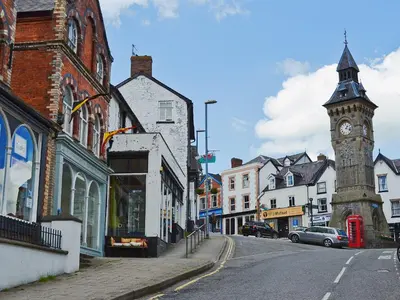 a town with a clock tower on a street at Heyope Cottage in Llangunllo