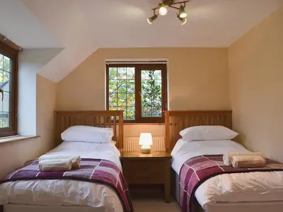 two beds in a room with two windows at Celyn in Montgomery