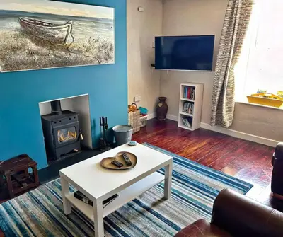 a living room with a white coffee table and a fireplace at The Rope and Anchor Aberaeron in Aberaeron