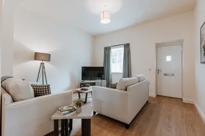 a living room with two couches and a tv at Tedsmore Cottages in Oswestry