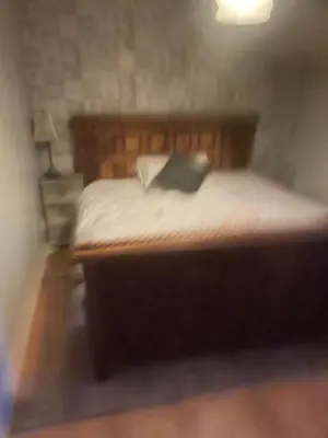 a bed with white sheets and a green pillow at Dolphin Inn in Llanymynech