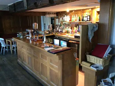 a bar with a wooden counter in a room at Dolphin Inn in Llanymynech