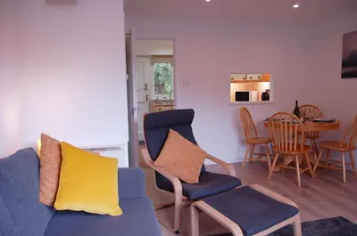 a living room with a blue couch and chairs and a table at No 6 at Dolgoch Falls Cottages in Bryn-crug