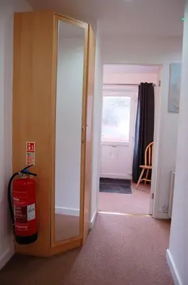 a room with a door and a room with a fire extinguisher at No 6 at Dolgoch Falls Cottages in Bryn-crug