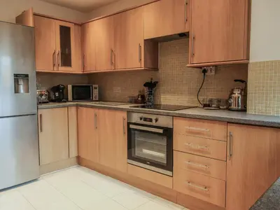 a kitchen with wooden cabinets and a stainless steel refrigerator at Riverbank in Shrewsbury