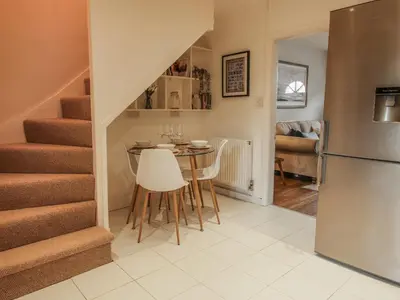 a kitchen and dining room with a table and stairs at Riverbank in Shrewsbury