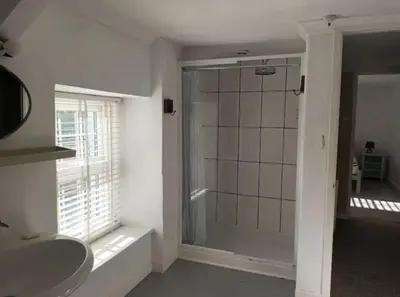 a bathroom with a shower and a sink at Drws Y Coed in Tal-gareg