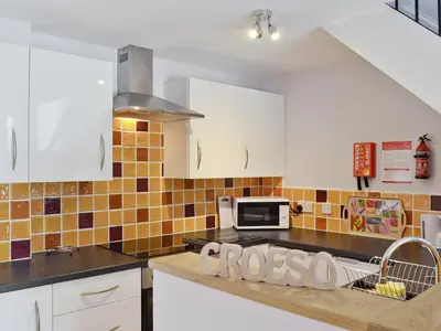 a kitchen with white cabinets and a microwave at The Granary - Or3 in Henfynyw Upper