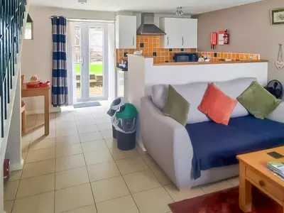 a living room with a couch and a kitchen at The Cow Shed - Or5 in Henfynyw Upper