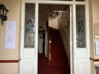 a hallway with a staircase with stained glass windows at The Cambrian in New Quay
