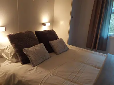 a bed with four pillows on top of it at Number 8 Lodge Caer Beris in Maesmynis