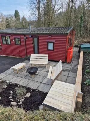 a red cabin with two benches and a grill at Number 8 Lodge Caer Beris in Maesmynis