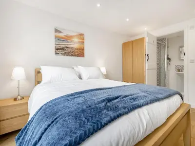 a bedroom with a large bed with a blue blanket at Orchard Barns - Uk47200 in Stapleton