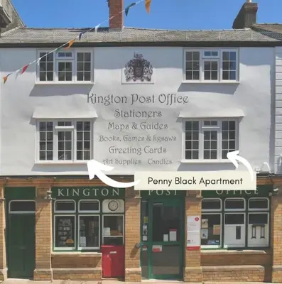 a building with a sign on the front of it at Penny Black Apartment, Kington in Kington