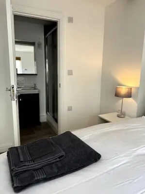 a black towel sitting on top of a bed at Penny Black Apartment, Kington in Kington