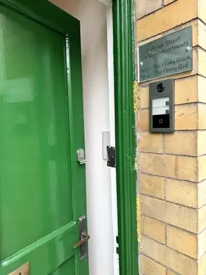 a green door with a sign on the side of a building at Penny Red apartment in Kington in Kington