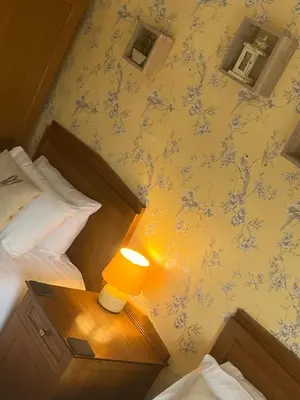 a bedroom with two beds and a lamp on a table at The Bull Hotel in Ludlow