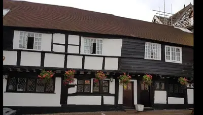 a black and white building with flowers in front of it at The Bull Hotel in Ludlow