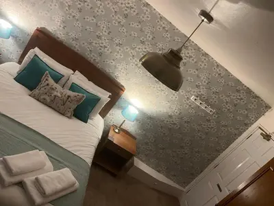 a bedroom with a bed with a blue wall at The Bull Hotel in Ludlow