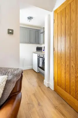a kitchen with a wooden door leading to a kitchen at Castell Bach in Llangollen