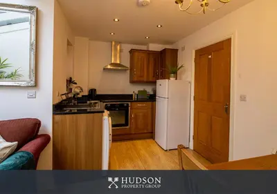 a kitchen with a white refrigerator and wooden cabinets at Shrewsbury Apartment in Prime Location in Shrewsbury