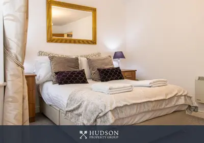 a bedroom with a bed with a mirror on the wall at Shrewsbury Apartment in Prime Location in Shrewsbury