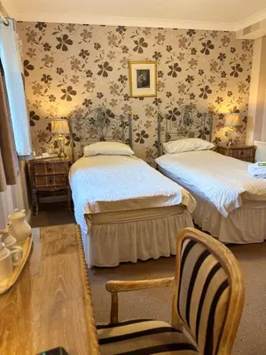 a bedroom with two beds and a table and chairs at Albright Hussey Manor in Shrewsbury