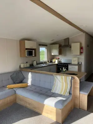 a living room with a couch and a kitchen at Weston pools lodge in Oswestry
