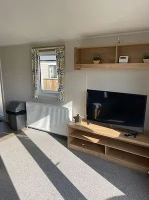 a living room with a flat screen tv at Weston pools lodge in Oswestry