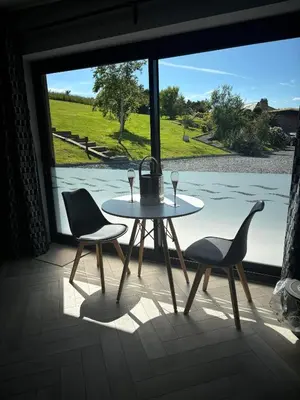 a table and two chairs in a room with a window at Sea Breeze Lodge in Aberaeron