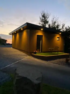 a small building with a table in front of it at Sea Breeze Lodge in Aberaeron
