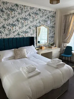 a bedroom with a large bed with two towels on it at Feathers Hotel Bar and Restaurant in Aberaeron