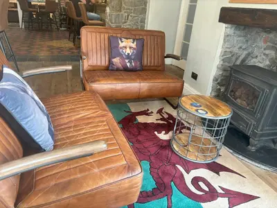 a living room with a couch and a fire place at Feathers Hotel Bar and Restaurant in Aberaeron