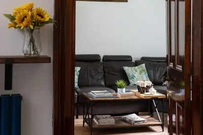 a living room with a couch and a table at Eryri Snowdonia Premier Family Retreat with Hot Tub and Fire Pit in Dolgellau