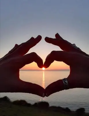 two hands in the shape of a heart in front of a sunset at Eryri Snowdonia Premier Family Retreat with Hot Tub and Fire Pit in Dolgellau