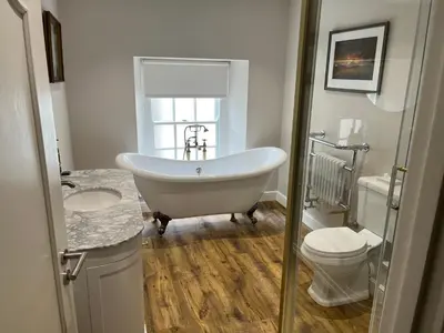 a bathroom with a tub and a toilet and a sink at The Castle Coaching Inn in Trecastle